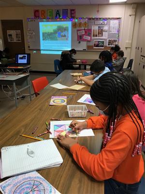 Photo shows Lincoln students working at a desk creating a colorful "Freedom Quilt"